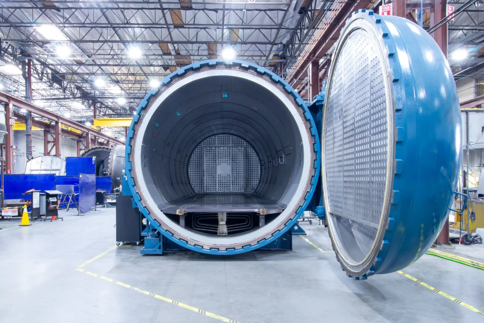 A blue ASC production Econoclave with its door swung open, looking down the bore to the H-Slot airflow panel at the rear