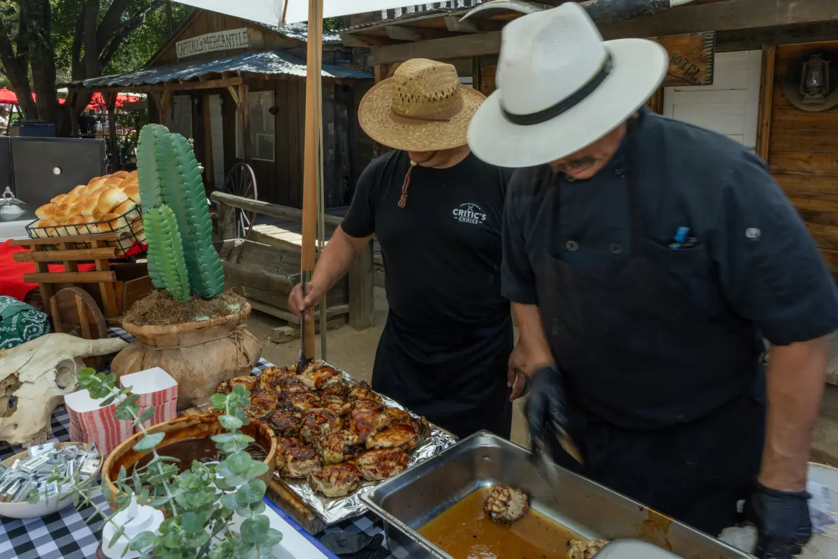 Cooks in cowboy hats serving from the chuck wagon