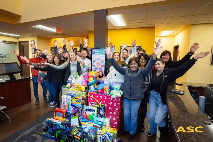 ASC staff cheering beside donated toys