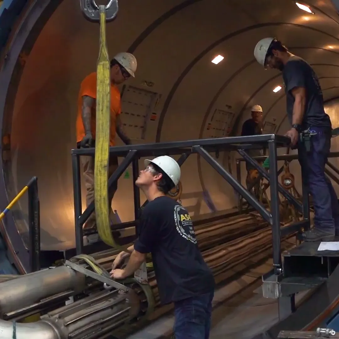 An ASC crew rigging equipment inside an open autoclave on the Valencia shop floor