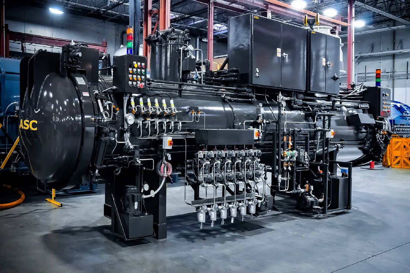 A black ASC autoclave with its control cabinets mounted on the vessel skid