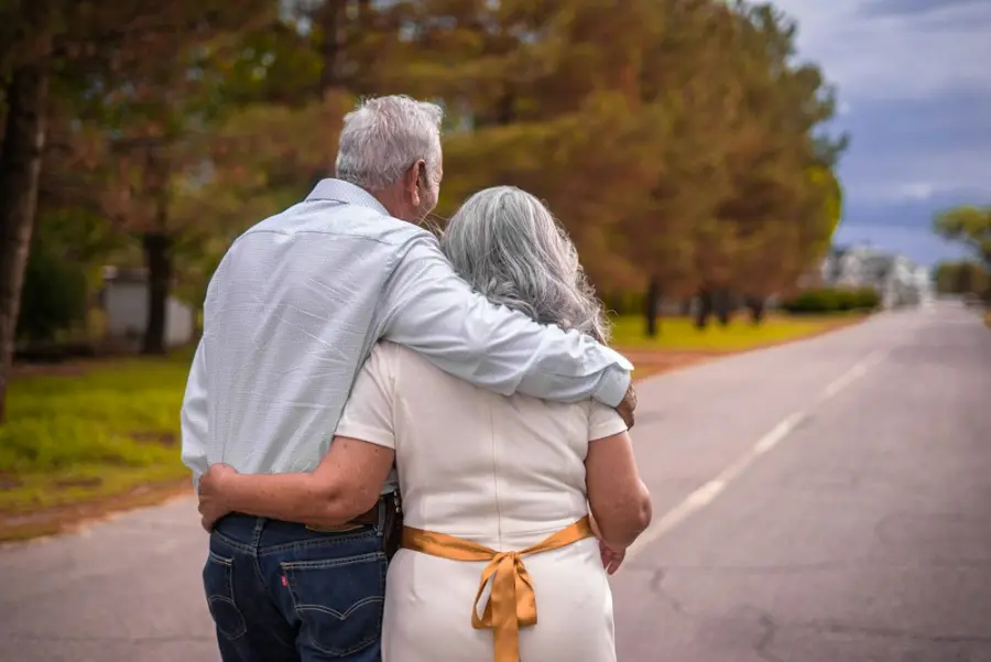 An older couple walking arm in arm