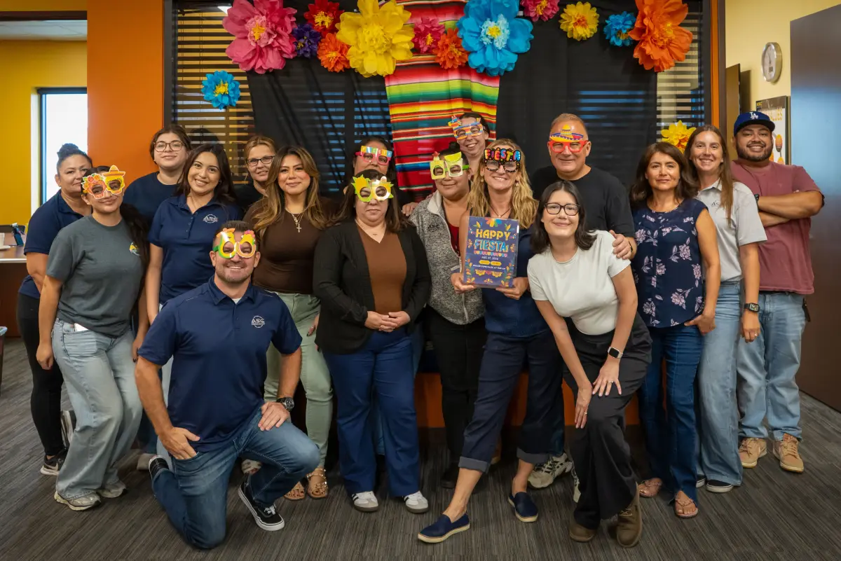 The ASC office team posing in party glasses at a fiesta