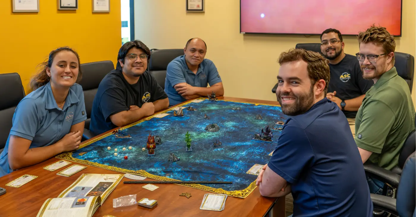 Coworkers around a board game table covered with pirate ships