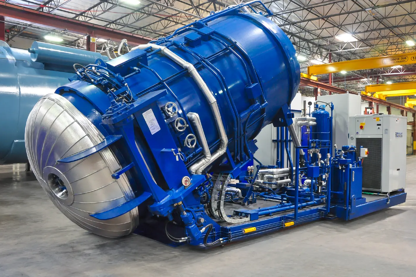 An ASC UF₆ autoclave tilted forward on its skid, with its chiller and control cabinets