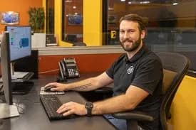 An ASC controls engineer working at his dual-monitor desk
